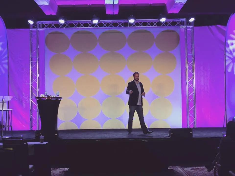 John Hall speaking on stage